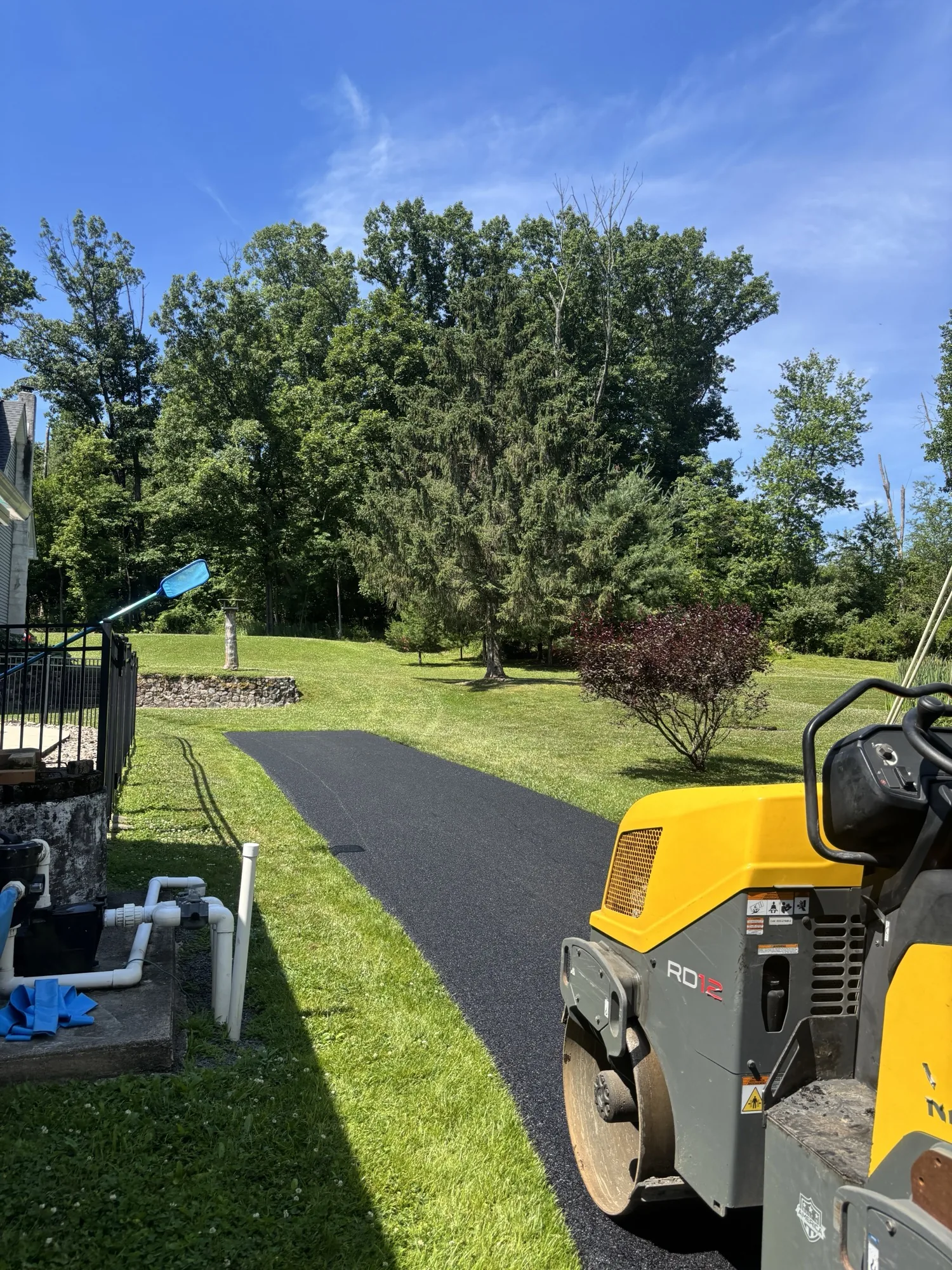 RDX roller compacting a fresh curved residential driveway after the hot-mix paving pass